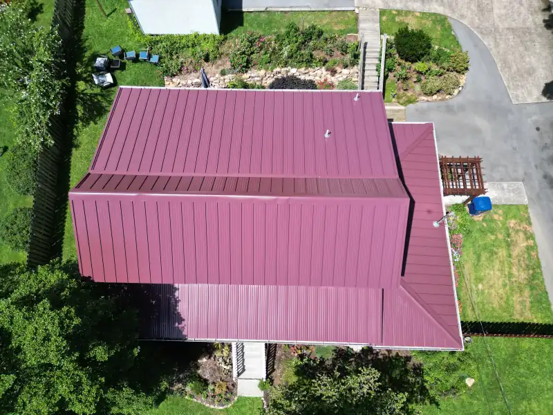 Top-down drone view of a red metal roof completed by Palisade Roofing in East Tennessee.