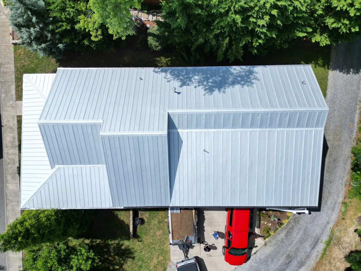 Non-painted standing-seam metal roof — bare Galvalume on a Tri-Cities farmhouse, a Palisade Roofing installation.